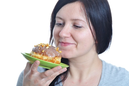 portrait of a young woman eating a donut against white background