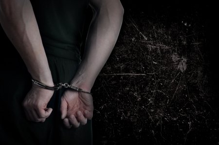 Men with handcuffs and grunge wall in backgroundの写真素材