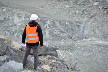 Worker in a helmet and quarry in backgroundの写真素材