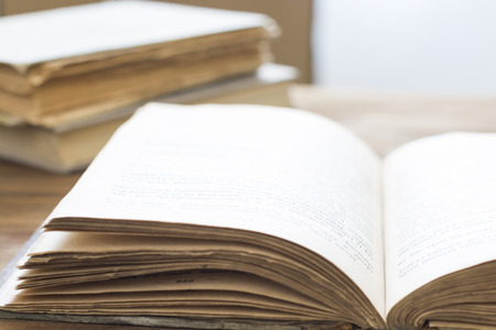 Closeup of open old book on wooden tableの写真素材