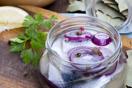 Marinated herring in a jar with spicesの写真素材