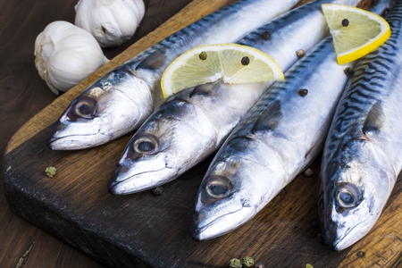 Mackerel with lemon and garlic at cutting tableの写真素材