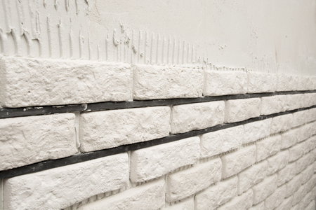 Installing white decorative bricks on the wallの写真素材