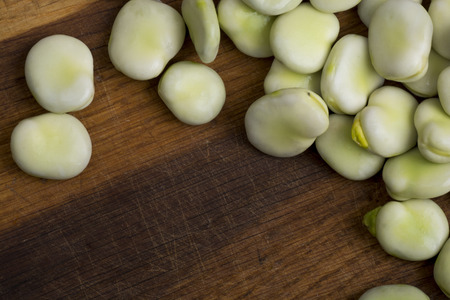 Fresh broad beans on wooden board