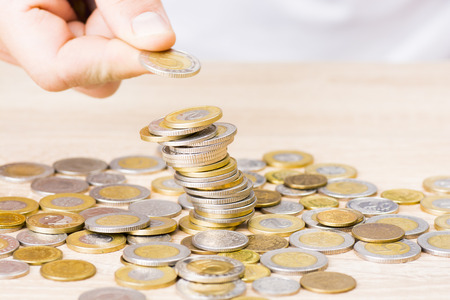 Man stacking coins on table
