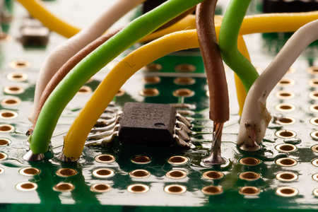 Closup of soldered cables in front of a microchip