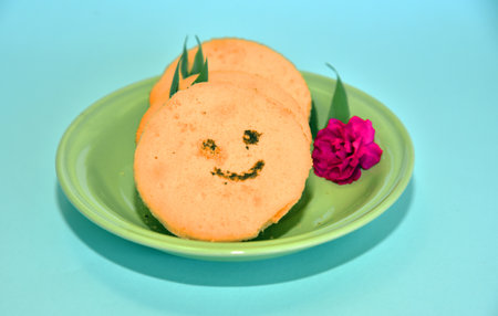 Smiling face cookies isolated with a blue light backgroundの写真素材