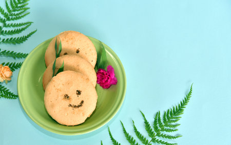 Smiling face cookies isolated with a blue light backgroundの写真素材