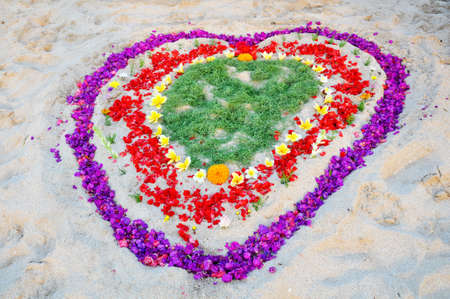 Flower decoration in love or heart format placed on the white sand beach during valentines day or wedding ceromony.の写真素材