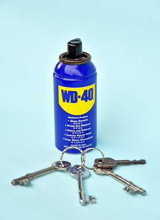BALI,INDONESIA-JULY 17,2021: A bottle of WD 40 with key as a forground isolated on light blue backgroundのeditorial素材