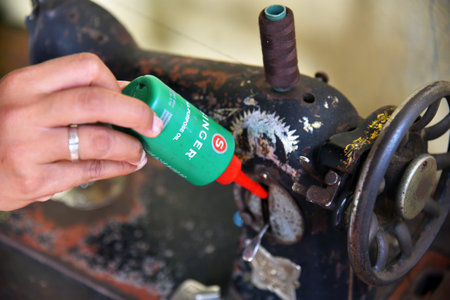 BALI,INDONESIA-JULY 22,2021: Sewing machine oil of Singer near the old Sewing Machine of Butterflyのeditorial素材