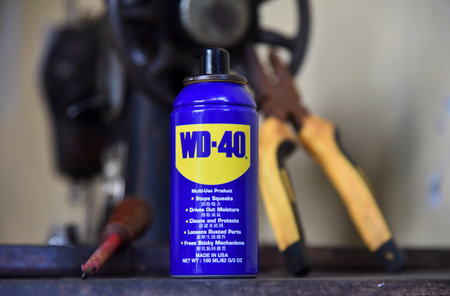 BALI,INDONESIA-JULY 22,2021: WD 40 oil, with a tong and screw driver placed on the old sewing machineのeditorial素材
