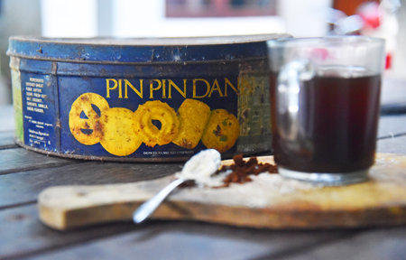 BALI,INDONESIA-JULY 22,2021: A cup of coffee with an old rusty empty box of PinPin Dan biscuitのeditorial素材
