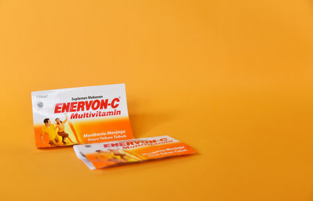 BALI,INDONESIA-AUGUST 09 2021: Multivitamin for adult in yellow color isolated on color backgroundのeditorial素材