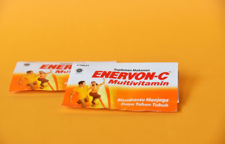 BALI,INDONESIA-AUGUST 09 2021: Multivitamin for adult in yellow color isolated on color backgroundのeditorial素材