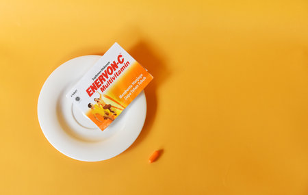 BALI,INDONESIA-AUGUST 09 2021: Multivitamin for adult in yellow color isolated on color backgroundのeditorial素材