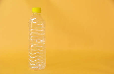 Empty water bottle isolated on yellow background
