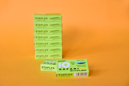 BALI,INDONESIA-AUGUST 09 2021: Staples in green box isolated on yellow backgroundのeditorial素材