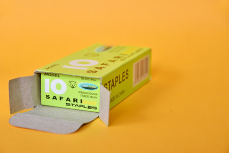 BALI,INDONESIA-AUGUST 09 2021: Staples in green box isolated on yellow backgroundのeditorial素材