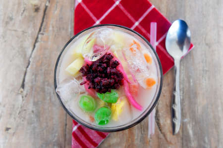 Mix ice,names in Indonesian language "Es Campur",serving on glass on brown wooden tableの写真素材