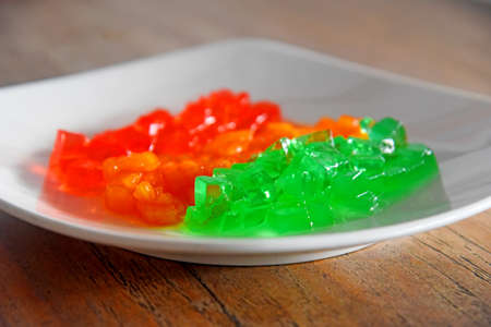 Colorful jelly drink,placed on white plate on brown wooden table