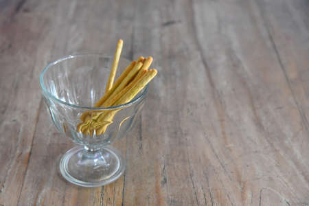 Bread sticks placed on the glass bowl,on the wooden background