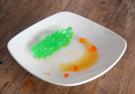 Colorful jelly drink,placed on white plate on brown wooden tableの写真素材