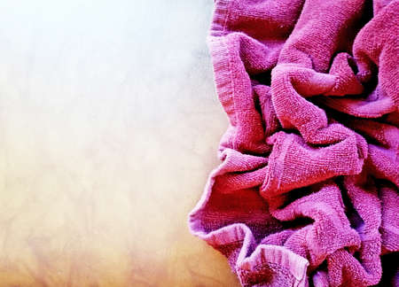 Purple,red color towel placed on brown backgroundの写真素材