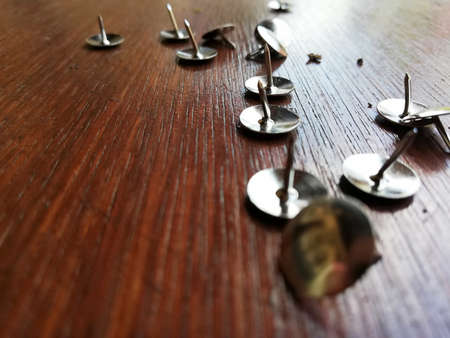 Thumbtack placed on brown wooden backgroundの写真素材