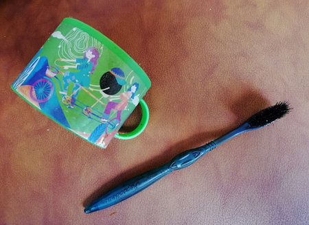 Bali,Indonesia - April 15 2022 : Toothbrush which used for hair coloring or shoe polishing,placed on brown wooden backgroundのeditorial素材
