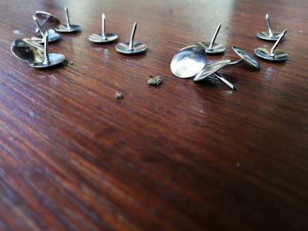 Thumbtack placed on brown wooden backgroundの写真素材