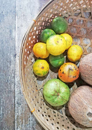 Fruits placed on bamboo basket, on brown wooden table