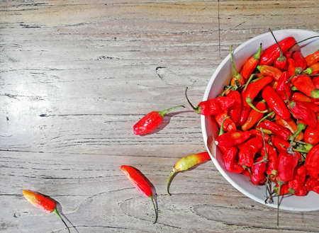 Red chili pepper placed on white bowl,on brown wooden backgrondの写真素材