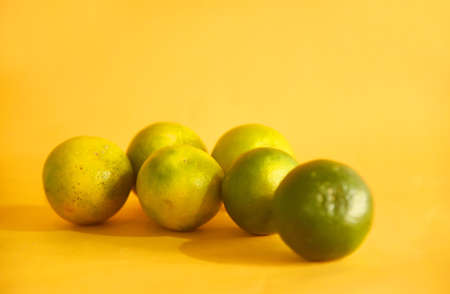 Orange fruit,isolated on yellow backgroundの写真素材