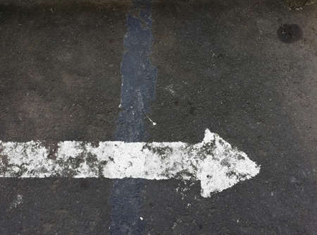 White arrow sign painted on the road