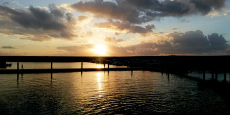 Sunset over the sea with reflection in the water and a bridge