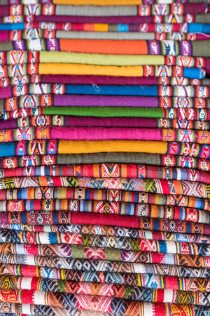 Colorful handmade peruvian blanket in different shapes made by wool selling in the market for...