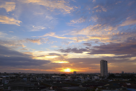 Sunset view of a blue sky with cloud over city downtown with houses and office buildingsの写真素材