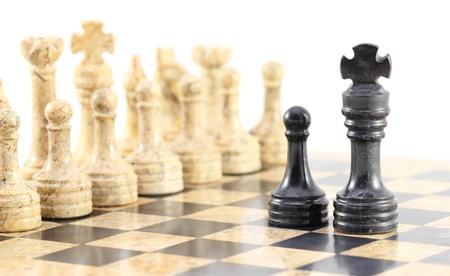 A pawn and his king face off against the entire army of opposing chess pieces.の写真素材