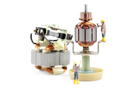 Macro photograph of a disassembled electric motor being worked on by two tiny toy engineers, concept.の写真素材
