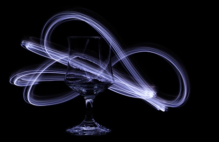 Swirling light trails dance around a glass chaliceの写真素材