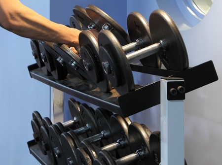 Two dumbbells being lifted from the rack.の写真素材