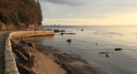 Vancouver, British Columbia, Canada - March 10, 2013: A couple watches the sunset over English Bay at Ferguson Point, on the western edge of Stanley Park.のeditorial素材