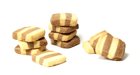 A batch of eleven vanilla and chocolate shortbread cookies isolated on a white background.の写真素材