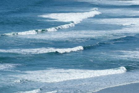 Atlantic waves breaking as they reach the British shore in Sennen Cove, Cornwall.