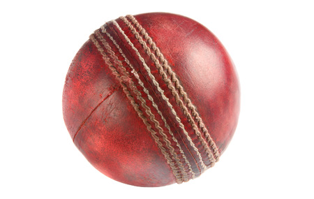 An old used red cricket ball, isolated on a white background.の写真素材
