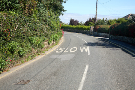 Slow sign on a bend in a Cornish road.の写真素材