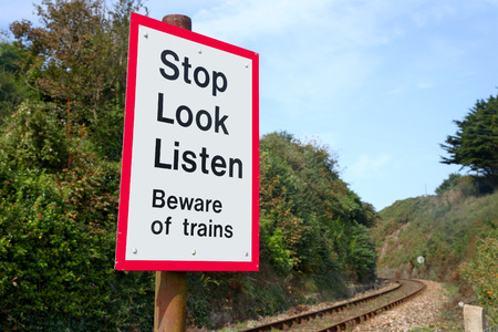 Beware of trains sign on a railway crossing.の写真素材