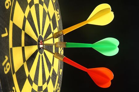 Three colourful darts in the bullseye.