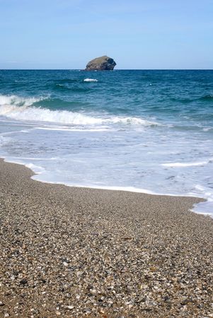 Waves breaking on the beach and Gull Rock in Porteath, Cornwall UK.の写真素材
